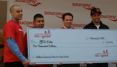 Top world sprinter Wallace Spearmon Jr presents check to Boston's YES.